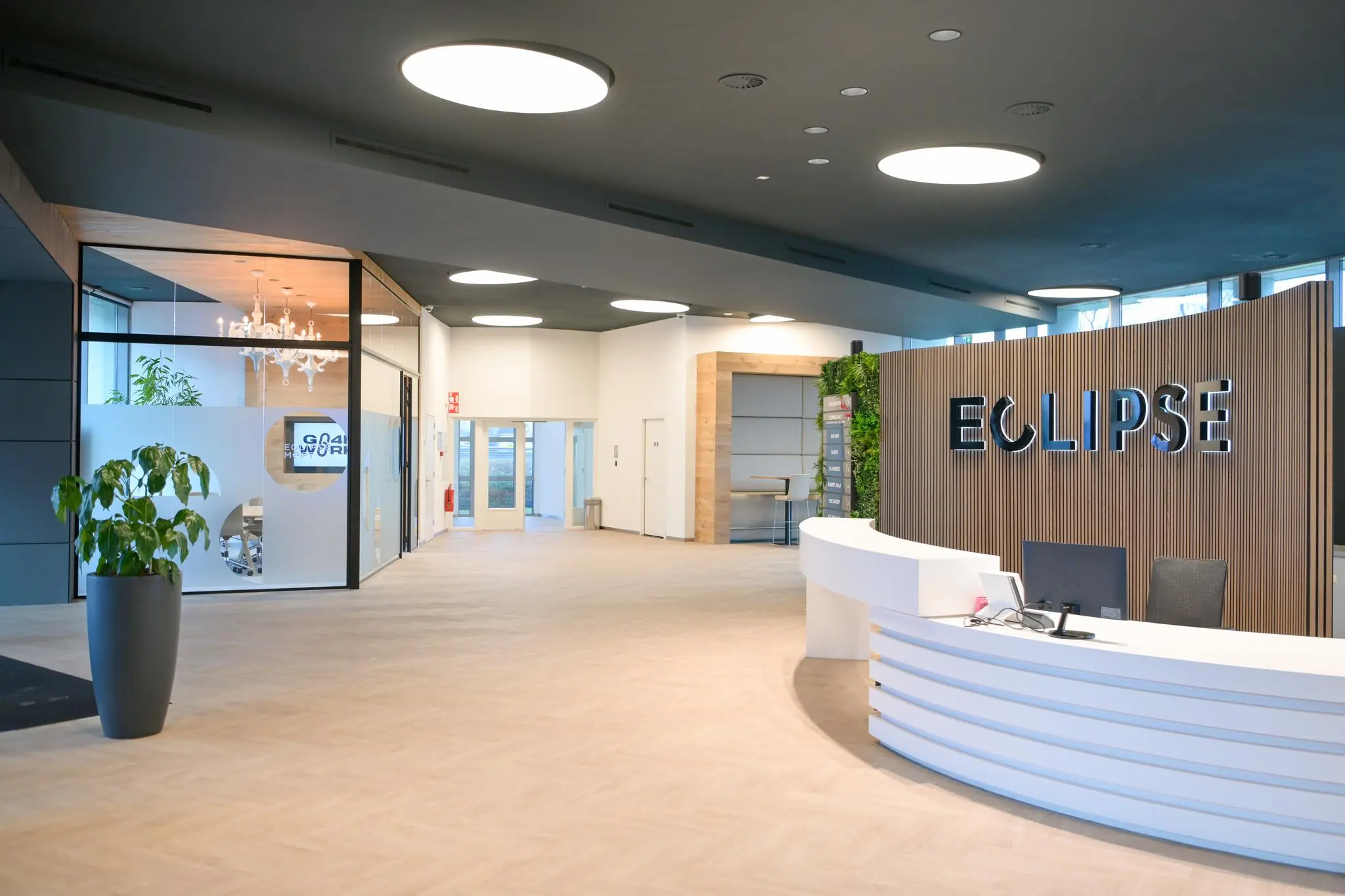 Moderne en lichte ontvangsthal van het kantoorgebouw Eclipse aan het Rivium Quadrant, met een receptiebalie en glazen vergaderruimte.